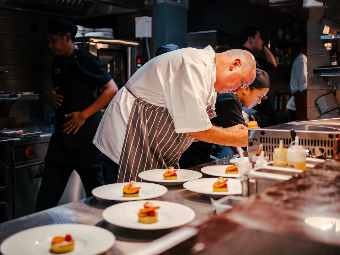 Chef Wade Watson plating with his team during service